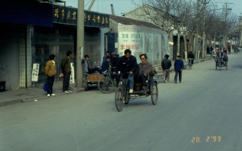 28.02.1993 in Suzhou / China. Das Strassenbild ist noch frei von Autoverkehr. Die Menschen sind zu Fu oder per Fahrrad unterwegs, so wie hier eine Fahrradrikscha der allerprimitivsten Bauart.