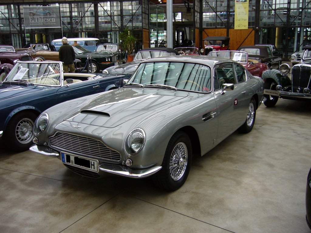 Aston Martin DB4. Gebaut wurden von 1958-1963 1.185 Fahrzeuge in 5 Serien. Dieses müßte ein Fahrzeug der 4. Serie sein, da es schon die Querstreben im Kühlergrill hat. Das DB in der Typenbezeichnung steht übrigens für David Brown. Meilenwerk Düsseldorf.