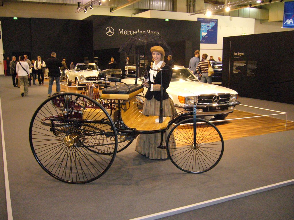 Benz Patent Motorwagen (Nachbau des ersten Benz Dreirades von 1886) mit einer als Bertha Benz  verkleideten  Hostess. Technoclassica