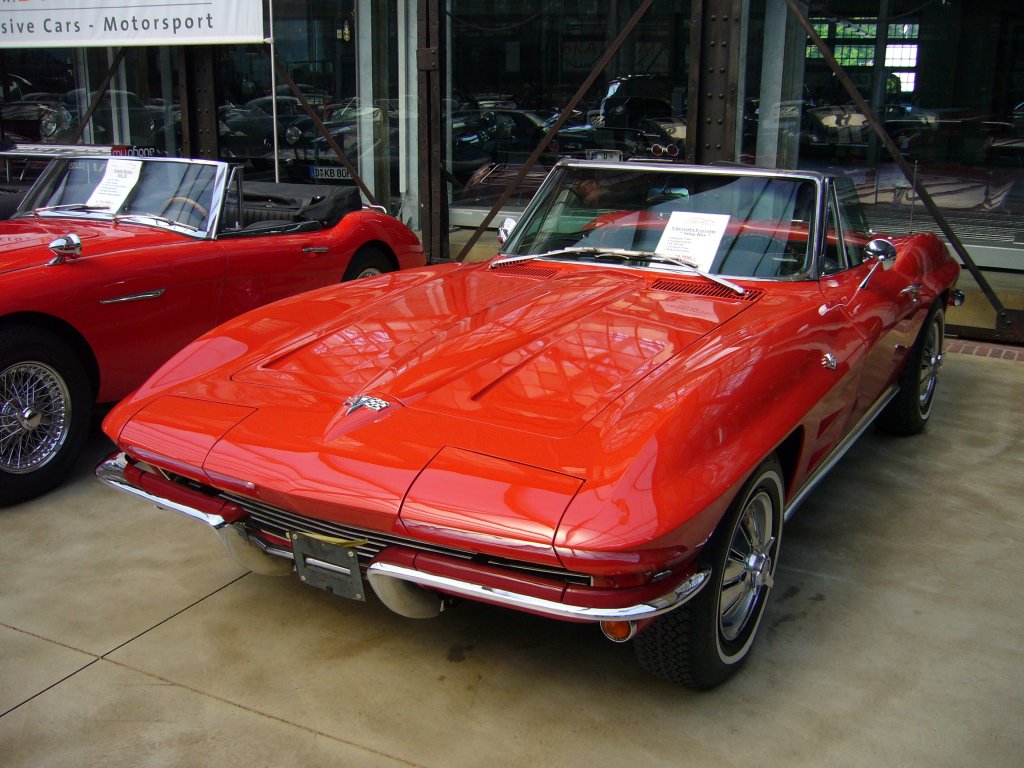 Chevrolet Corvette Stingray Convertible des Jahrgangs 1964. Die Originalfarbbezeichnung lautete Riverside red. Das Cabrio wurde in 1964 13.925 mal verkauft. Das Stingray Sport Coupe brachte es auf 8.304 Exemplare. Meilenwerk Dsseldorf.
