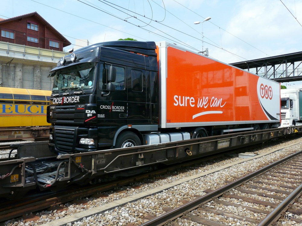 Ein DAF XF Sattelschlepper auf einer Rolla beim Zwischenhalt im Bahnhof Spiez am 01.07.2011