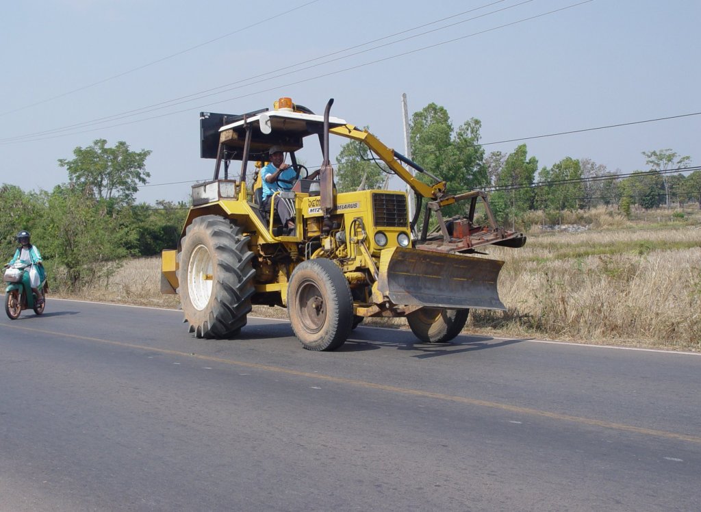 Ein MTZ Belarus Traktor ist eingesetzt beim Abmhen der Grser am Straenrand. Gesehen am 11.02.2011 bei Nong Khai im Nordosten Thailands