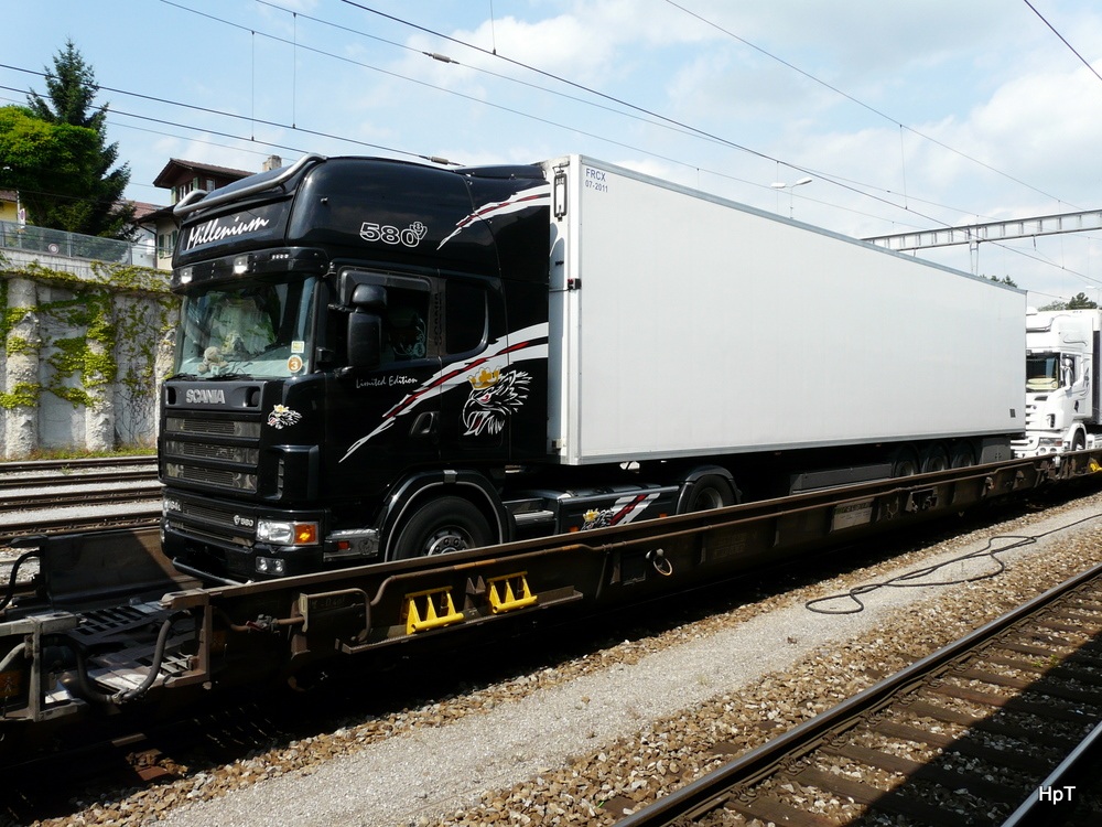Ein Scania 164L 580 Sattelschlepper auf einer Rolla beim Zwischenhalt im Bahnhof Spiez am 01.07.2011