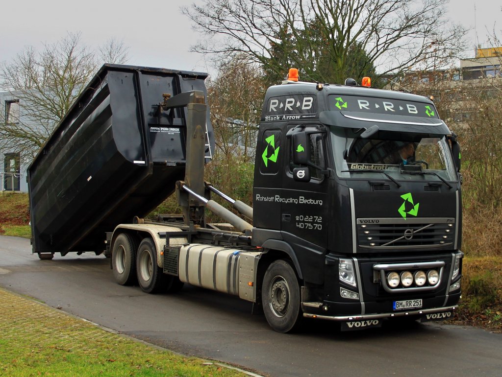 Ein schner schwarzer Volvo FH der Firma Rohstoff Recycling Bedburg (RRB) setzt am 24.01.2012 einen Abrollcontainer an der Kopernikusstrae ab.