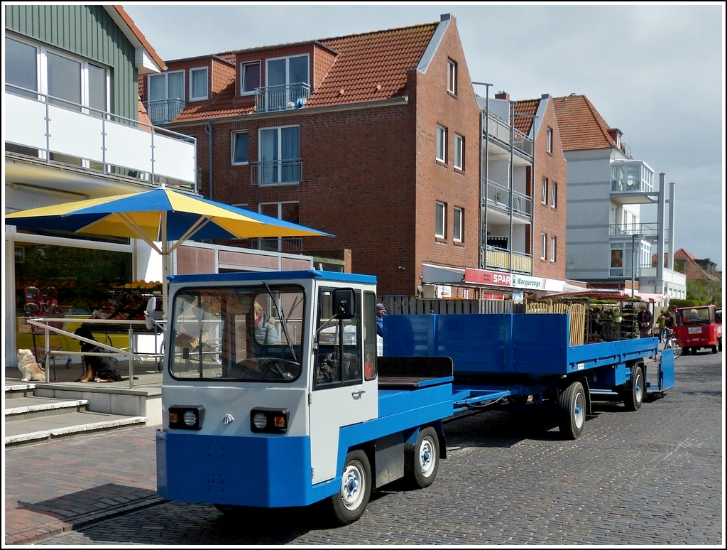 Kleines Elektrofahrzeug mit einen groen Anhnger, gesehen auf der Insel Wangerooge am 07.05.2012.