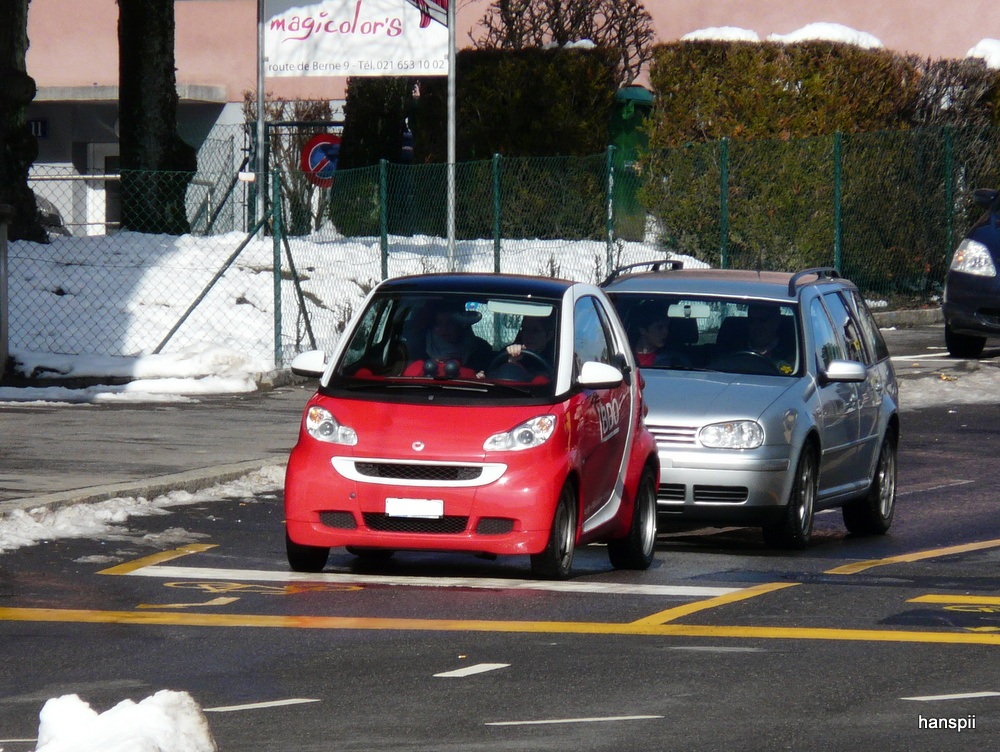Rot und Weisser Smart unterweg in der Stadt Lausanne am 16.02.2013