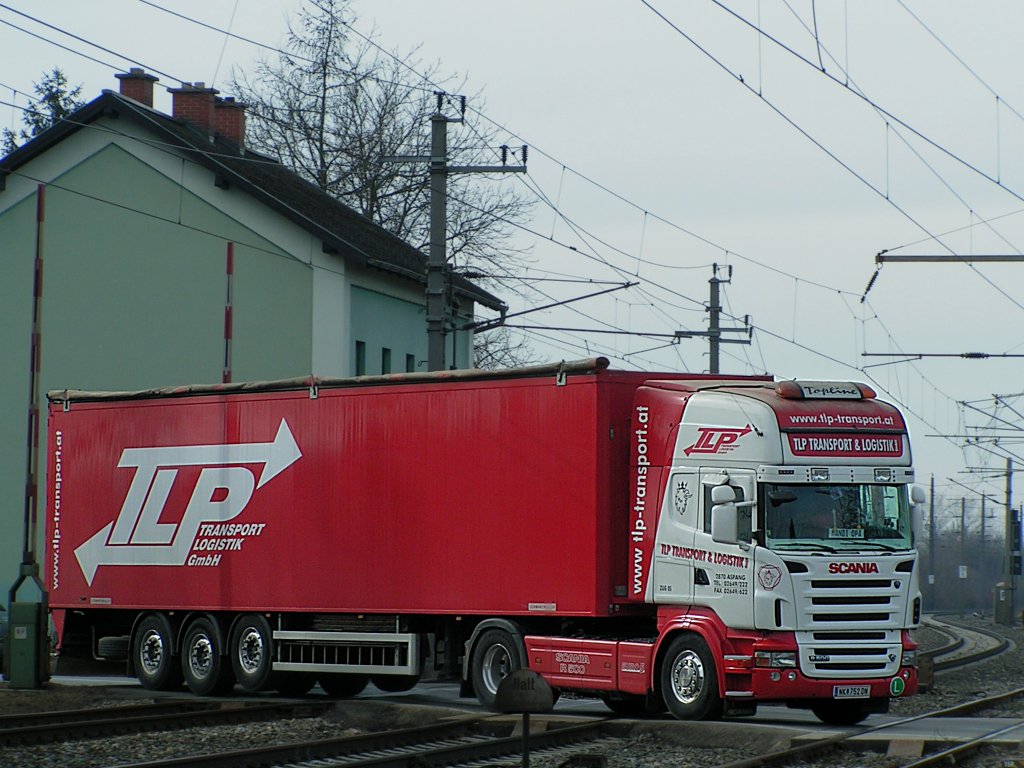 SCANIA-R500 von TLP quert bei Bruck/Leitha einen Bahnbergang;100223