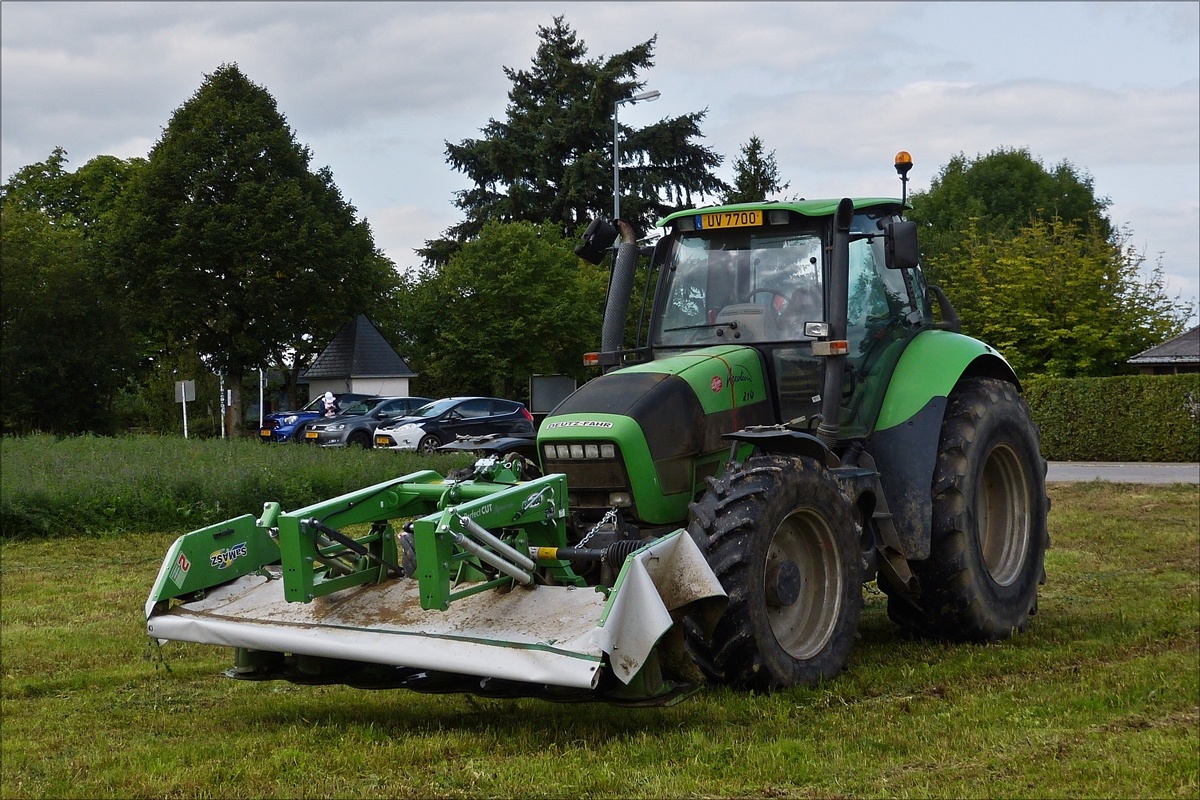 . Deutz Fahr Traktor mit Frontmäher gesehen auf einem Grasfeld.  August 2017