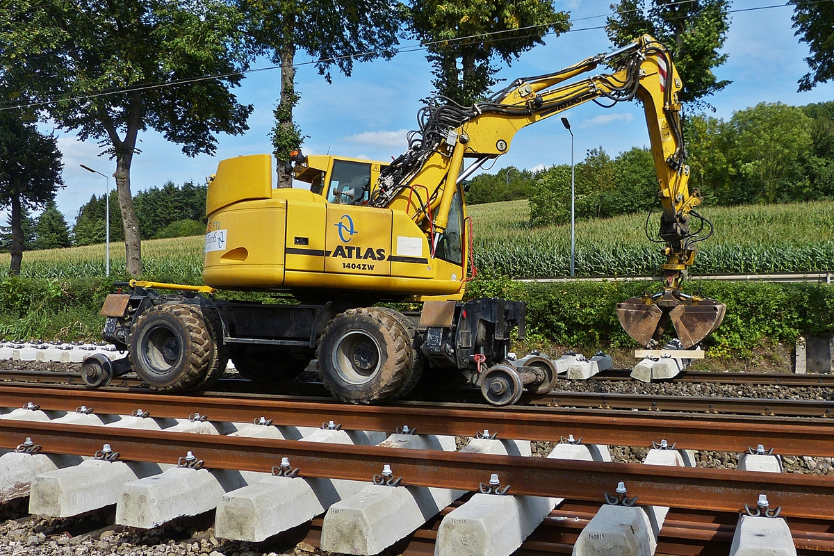 . Zweiwegebagger Atlas 1404 ZW legt die Betonschwellen in einer Reihe bereit, um danach die Schienen darauf zu befestigen.  Bahnbaustelle Schieren 25.08.2015
