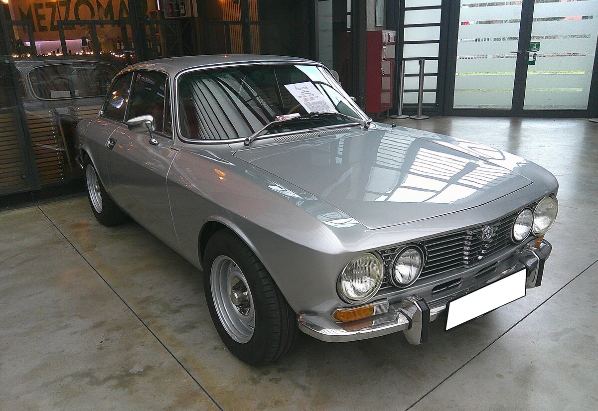 Alfa Romeo 2000 GT Veloce (kurz GTV), produziert in den Jahren von 1971 bis 1976. Der in 44.301 Einheiten produzierte 2000 GTV war das Spitzenmodell der bereits seit 1963 gebauten  Junior  Modell-Reihe. Motorisiert mit einem Vierzylinderreihenmotor mit einem Hubraum von 1.962 cm³ und einer Leistung von 131 PS machten diesen, damals noch erschwinglichen Sportwagen, 200 km/h schnell. Der gezeigte Wagen aus dem vorletzten Modelljahr 1975 dürfte im Farbton argento lackiert sein. Classic Remise Düsseldorf am 15.01.2026.