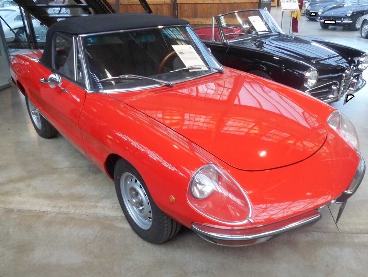 Alfa Romeo 2000 Spider Veloce aus dem Jahr 1974. Im Jahr 1969 begann für den Alfa Romeo Spider die Fastback-Ära. Diese so genannte  coda-tronca-Optik  gab dem Zweisitzer einen modernen Touch. Auch im Innenraum gab es Änderungen. Auffälligstes Merkmal waren die zwei  Eisbecher , die jetzt die Instrumente einrahmten, was ungemein sportlich aussah. Die Scheinwerferverglasungen waren in einigen Ländern im Lieferumfang enthalten. Angetrieben wird der Spider von einem Vierzylinderreihenmotor mit einem Hubraum von 1962 cm³ und einer Leistung von 131 PS. Classic Remise Düsseldorf am 15.01.2026.