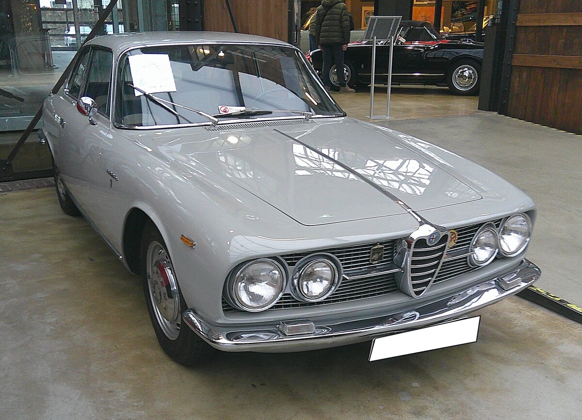 Alfa Romeo 2000 Sprint Coupe, wie er nur in den Jahren 1961 und 1962 in 704 Einheiten produziert wurde. Der von Bertone gezeichnete  Sprint  sollte sich richtungsweisend für die Coupe Linie der Marke aus Milano erweisen. Sowohl in technischer als auch in optischer Hinsicht. Der Vierzylinderreihenmotor mit DOHC-Technik hat einen Hubraum von 1975 cm³ und leistet 115 PS. Die Höchstgeschwindigkeit wurde seinerzeit mit 172 km/h angegeben. Zum richtigen Gentleman-Sportwagen wurde wurde das Modell aber erst, als der Sprint 2000 im Sommer 1962 durch den sechszylindrigen Sprint 2600 abgelöst wurde. Das gezeigte Alfa Romeo 2000 Sprint Coupe im Farbton grigio chiaro wurde im März 1961 erstmalig in der toskanischen Provinzhauptstadt Firenze (Florenz) zugelassen. Classic Remise Düsseldorf am 15.01.2026.