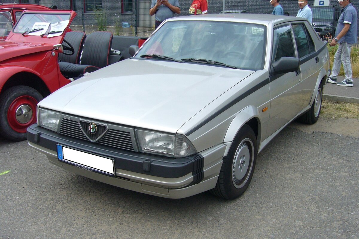 Alfa Romeo 75 3.0 V6 America, produziert in den Jahren von 1987 bis 1990. Der Alfa Romeo 75 wurde im Jahr 1985 zum 75´ten Geburtstag der Marke aus Mailand vorgestellt. Der Kunde konnte das Modell in etlichen Benzin- und Dieselmotorisierungen bestellen. Im August 1987 wurde das Spitzenmodell 3.0 V6 auf den Markt gebracht. Unter der Motorhaube verrichtet ein V6-Motor seinen Dienst, der aus einem Hubraum von 2959 cm³ 185 PS leistet. Oldtimertreffen an der  Alten Dreherei  in Mülheim an der Ruhr am 18.06.2023.