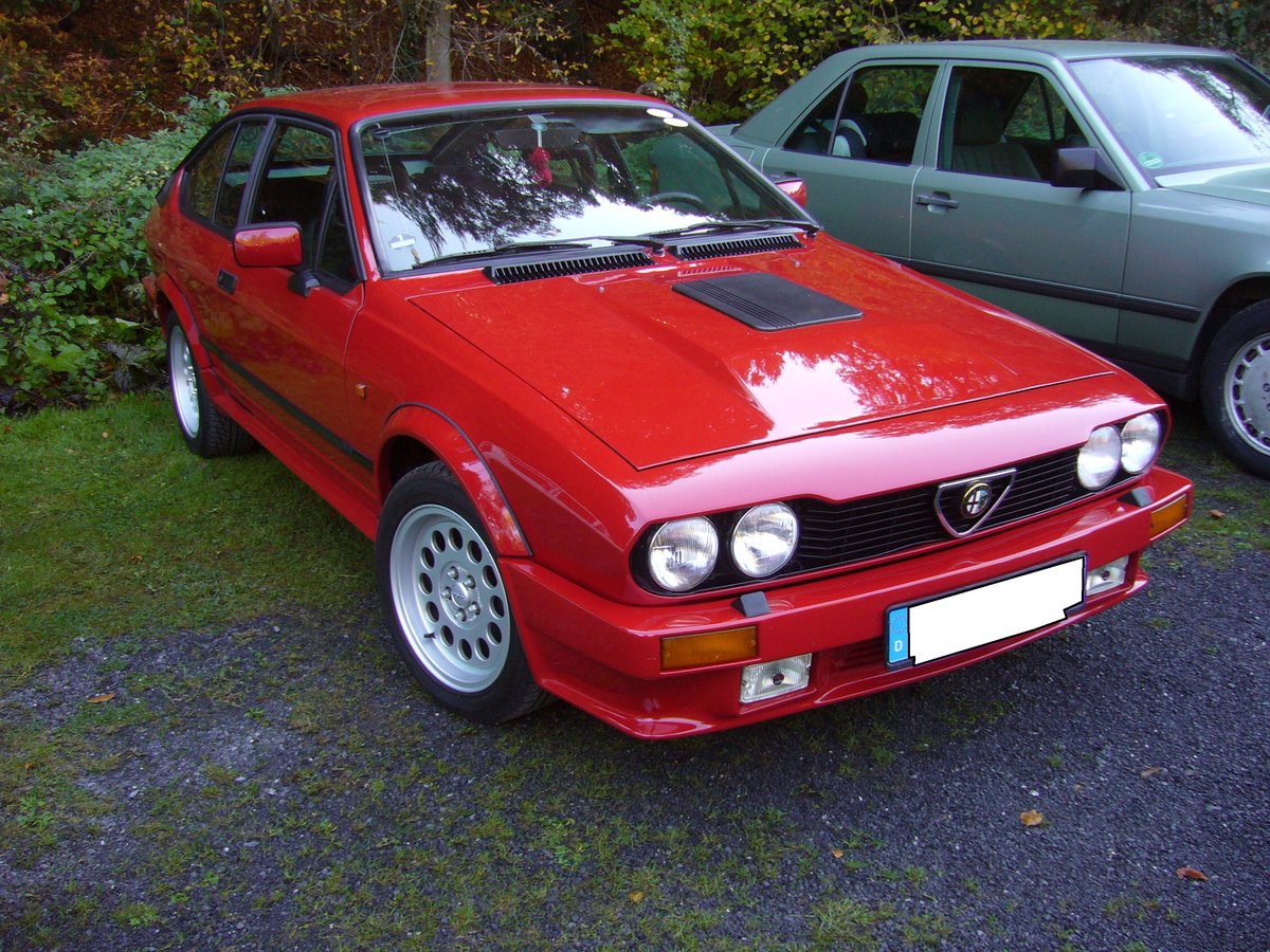 Alfa Romeo Alfetta GTV, gebaut von 1974 bis 1986. Während der dreizehnjährigen Produktionszeit durchlief das Modell etliche optische (Facelifts) und technische Veränderungen. Hier wurde ein Modell der Baujahre 1980 bis 1986 abgelichtet. Aufgrund der Hutze auf der Motorhaube, müsste es sich um eine Alfetta GTV6 handeln. Der V6-motor hat einen Hubraum von 2492 cm³ und leistet 160 PS. Die Höchstgeschwindigkeit wurde damals mit 205 km/h angegeben. Oldtimertreffen  Schwarzwaldhaus  in Mettmann am 21.10.2018.