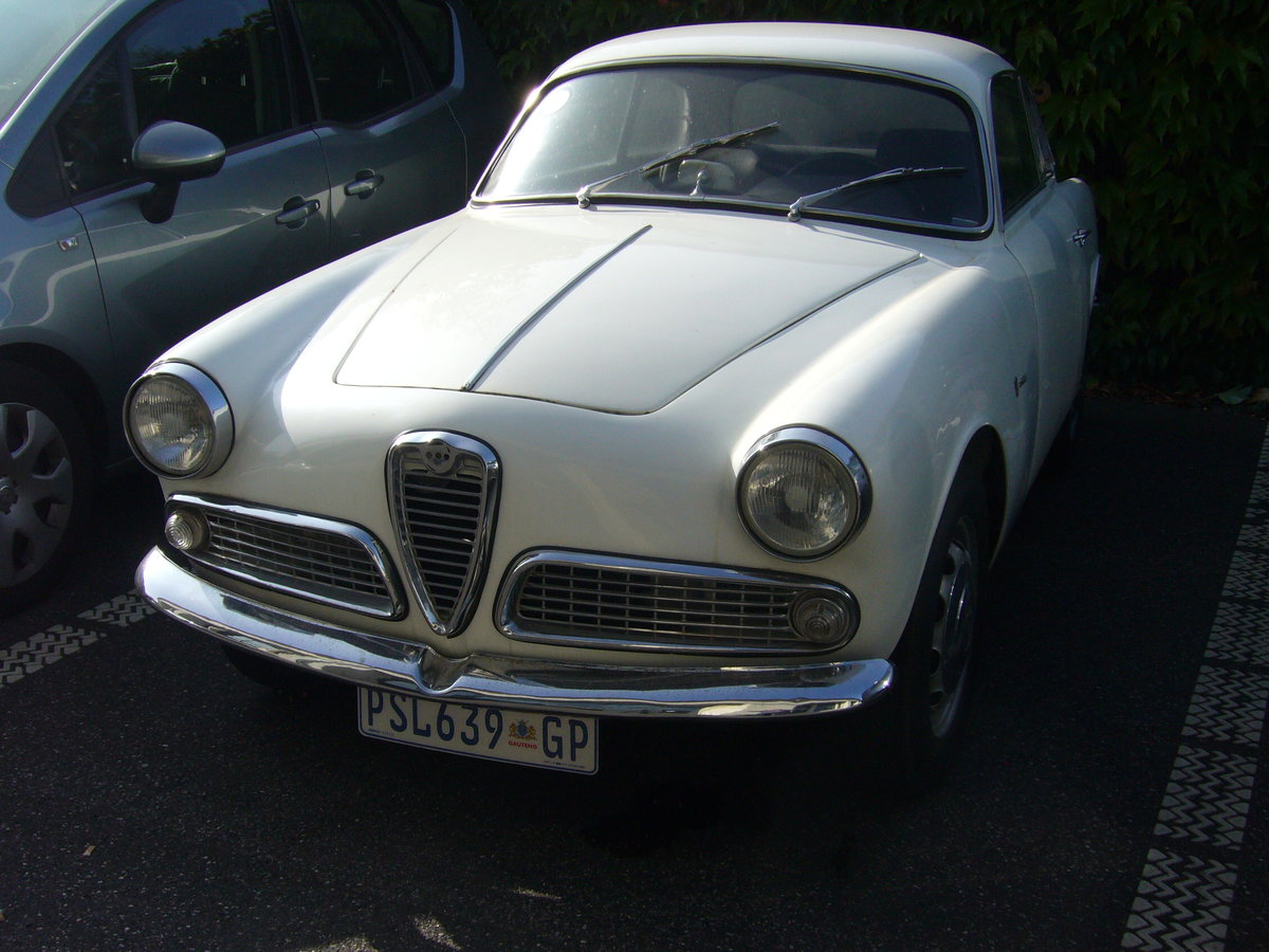 Alfa Romeo Giulietta Sprint 1300 der Seria 2 aus dem Jahr 1958. Der Wagen ist in Monaco zugelassen. Das Modell wurde auf dem Turiner Autosalon des Jahres 1954 vorgestellt. Als der Salon nach einer Woche zu Ende ging hatten ca. 3000 Kunden eine Bestellung für ein solches Coupe unterschrieben. Das Modell wurde bis 1964 in drei Serien hergestellt. Das gezeigte Auto der zweiten Serie wird von einem Vierzylinderreihenmotor angetrieben, der aus einem Hubraum von 1290 cm³ eine Leistung von 80 PS an die Hinterachse weiterleitet. Die Höchstgeschwindigkeit wurde mit 160 km/h angegeben. Besucherparkplatz der Düsseldorfer Classic Remise am 17.09.2020.