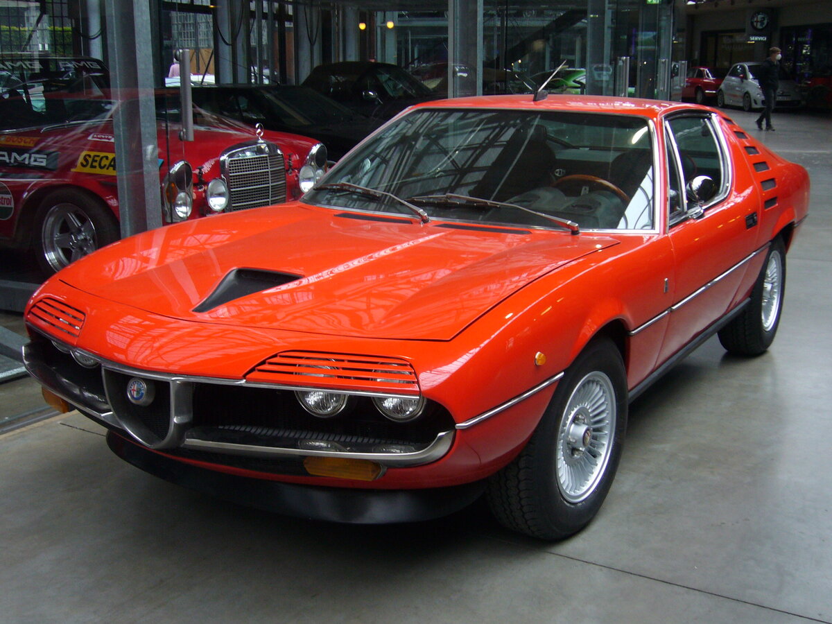 Alfa Romeo Montreal. Produziert wurden von 1970 bis 1977 insgesamt 3917 Autos dieses Typs. Der Wagen wurde als Designstudie im Jahr 1967 auf der Weltausstellung (Expo) in Montreal vorgestellt. Da dieser hübsche Sportwagen großen Anklang fand, ging er ab 1970 in Serie. Den Namen seines Vorstellungsortes behielt er bei. Der V8-Motor hat einen Hubraum von 2.593 cm³ und leistet 200 PS. Das Fahrwerk wurde vom Typ 105 (Giulia) übernommen. Classic Remise Düsseldorf am 07.06.2021.