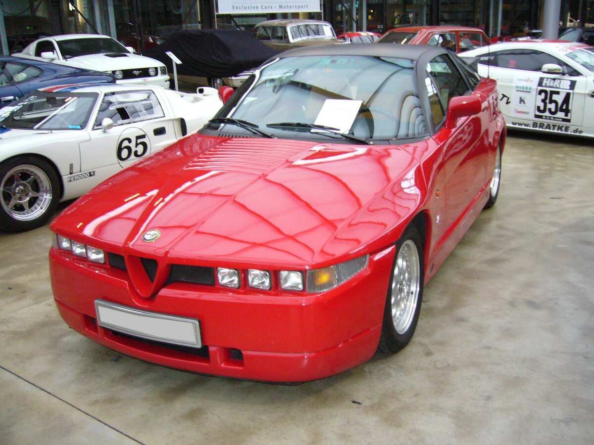 Alfa Romeo SZ. Der von 1989 bis 1991 in einer limitierten Serie von nur 1000 Stück gebaute SZ knüpfte an die sportlichen Traditionen von Alfa Romeo an. Die Karosserie mit ihrem eigenwilligen Design stammt zwar nicht von Zagato, wurde aber in dessen Karosserieschmiede gefertigt. Der V6-Motor hat einen Hubraum von 2959 cm³ und leistet 210 PS. Die Höchstgeschwindigkeit gab das Werk mit 245 km/h an. Classic Remise Düsseldorf.