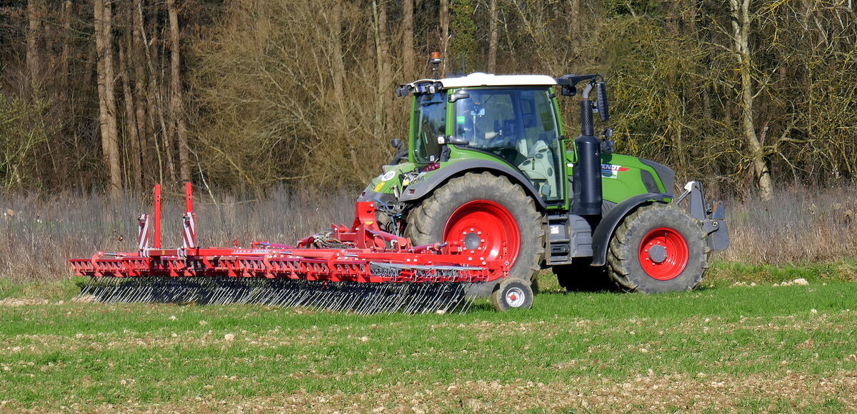 Allradschlepper FENDT mit Feldstriegel AGRIFARM bei der Bodenpflege und Unkrautbek�mpfung auf einem Feld mit Wintergetreide, M�rz 2026