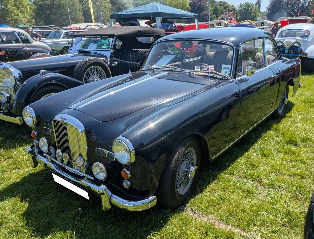 Alvis TD21 MK1 Coupe. Entwickelt wurde die Karosserie vom Karosseriewerk Graber aus Wichtrach bei Bern/Schweiz. Der Wagen ist mit einem so genannten  Nardi-Kit  ausgestattet. Das bedeutet die attraktiven Borrani Speichenfelgen und ein Holzlenkrad aus dem Hause Nardi. Angetrieben wird der Wagen von einem Sechszylinderreihenmotor mit einem Hubraum von 2993 cm� und einer Leistung von 120 PS. Die H�chstgeschwindigkeit wurde mit ca. 170 km/h angegeben. Der gezeigte TD21 wurde im Juli 1960 erstmalig zugelassen. Abergavenny Steam and Vintage Show am 27.05.2023.