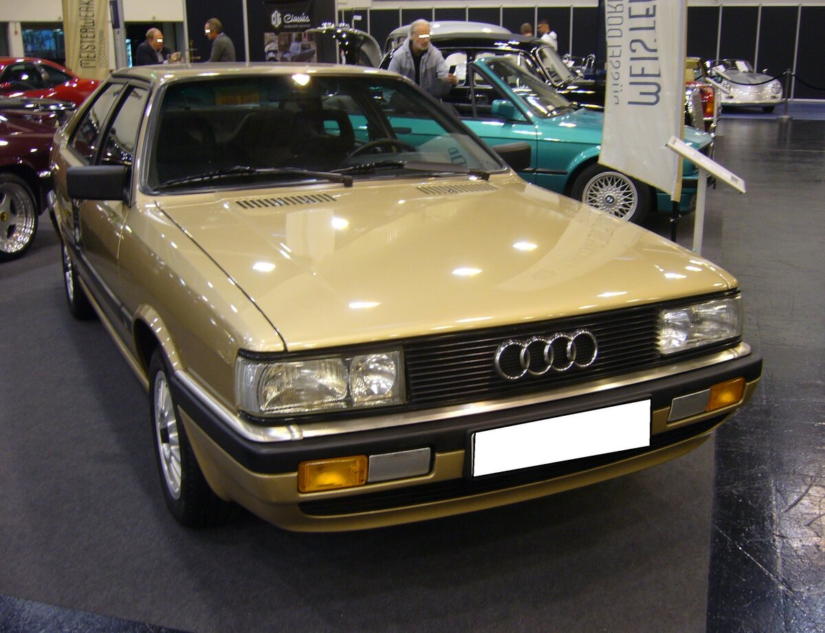Audi B2 Coupe der Modelljahre 1984 bis 1987. Das Audi Coupe war im Grunde eine Mischung aus der Karosserie des Quattro mit der Technik und dem Chassis des Audi 80. Der Wagen im Farbton mandelbeige metallic wird von einem Vierzylinderreihenmotor angetrieben, der aus einem Hubraum von 1781 cm³ 90 PS leistet. Essen Motorshow am 06.12.2023.