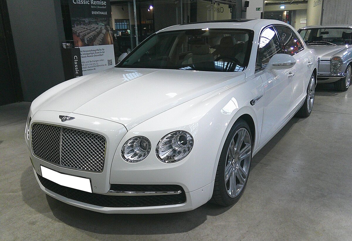 Bentley Flying Spur der ersten Serie, wie er auf dem Genfer Salon des Jahres 2013 vorgestellt wurde. Bis zum Erscheinen der zweiten Generation setzte die VW-Tochter Bentley rund 37.000 dieser Autos weltweit ab. Anfangs war das Modell nur mit einem W12-Motor mit einem Hubraum von 5998 cm³ und einer Leistung von 625 PS bzw. 635 PS beim W12 S-Modell lieferbar. Nach den Werksferien des Jahres 2014 konnte der  Flying Spur  auch mit einem V8-Motor bestellt werden. Dieser hat einen Hubraum von 5993 cm³ und leistet 507 PS bzw. 528 PS beim Model V8 S. Classic Remise Düsseldorf am 15.01.2026.