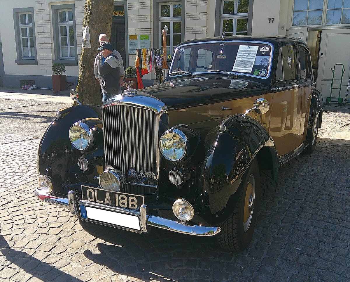 Bentley R-Type Saloon aus dem Jahr 1953. Der R-Type war kein wirklich neues Modell, sondern ein modernisierter Bentley MK VI. Er hatte allerdings einen größeren Kofferraum als sein Vorgänger und die Motorhaube war zweiflügelig zu öffnen. Außerdem war serienmäßig eine heizbare Heckscheibe verbaut. Ab 1953 hielt eine, in Lizenz von General Motors hergestellte, Viergangautomatic (drei Gänge plus Overdrive) Einzug. Zunächst nur für die Exportmodelle, ab 1954 auch für die Heimatmarktmodelle. Vom R-Type wurden insgesamt bis ins Jahr 1955 2.320 Fahrzeuge mit den verschiedensten Karosserieaufbauten etlicher  Coachworker  produziert. Der Sechszylinderreihenmotor hat einen Hubraum von 4515 cm³ mit einer Leistung von 135 PS. Laut Expose am Fahrzeug soll eine Höchstgeschwindigkeit von 160 km/h möglich gewesen sein. 18. Kettwiger Oldtimerfrühling in Essen Kettwig am 01.05.2026.