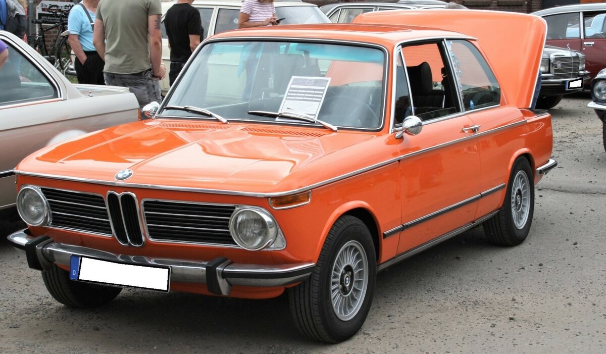 BMW 2002, produziert von 1968 bis 1975. Hier wurde ein 2002 abgelichtet, der zwischen April 1971 und September 1973 produziert wurde, da er schon die seitlichen Gummizierleisten trägt, aber noch mit den runden Heckleuchten ausgestattet ist. Das Fahrzeug ist im Farbton inkaorange lackiert. Der Vierzylinderreihenmotor leistet 100 PS aus einem Hubraum von 1.990 cm³. Oldtimertreffen an der  Alten Dreherei  in Mülheim an der Ruhr am 18.06.2022.