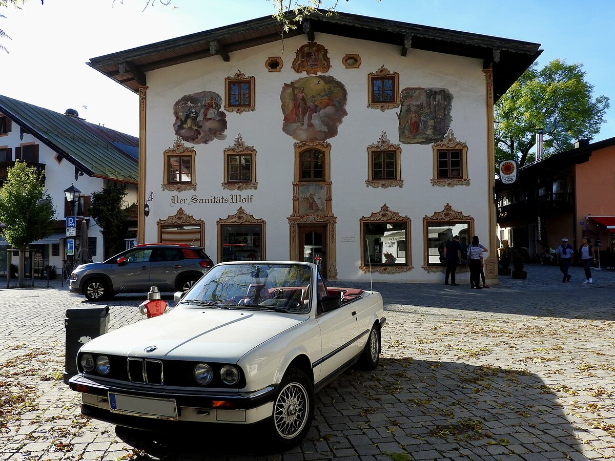 BMW 320i in Cabrio-Ausführung vor einem der wunderschön verzierten Häuser in Oberammergau; 211002