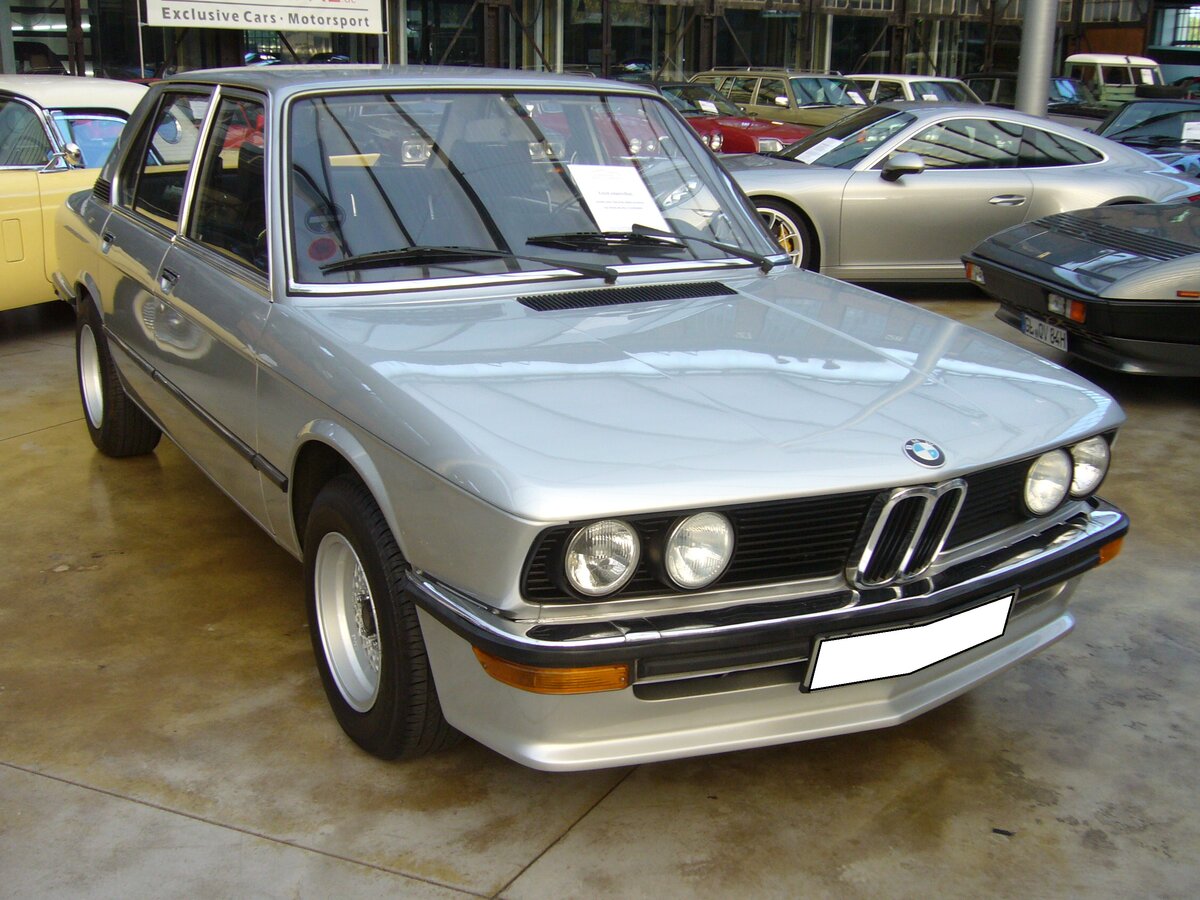 BMW E12 518, produziert von 1974 bis 1980. Das Modell E12 löste im September 1972 das Vorgängermodell BMW 2000 (neue Klasse) ab. Ein großer Teil der technischen Komponenten blieb erhalten, während sich die Karosserie wesentlich voluminöser präsentierte. Ab 1974 wurde das Basismodell 518 in die Modellpalette mit aufgenommen. Ein solcher BMW 518 war bei seinem Erscheinen im Juni 1974 ab DM 14.870,00 zu Haben. Der gezeigte E12 ist im Farbton polarissilber lackiert und wurde im April 1975 erstmals zugelassen. Das Auto ist mit einem Vierzylinderreihenmotor ausgerüstet, der aus einem Hubraum von 1766 cm³ 90 PS leistet. Classic Remise Düsseldorf am 28.09.2021.
