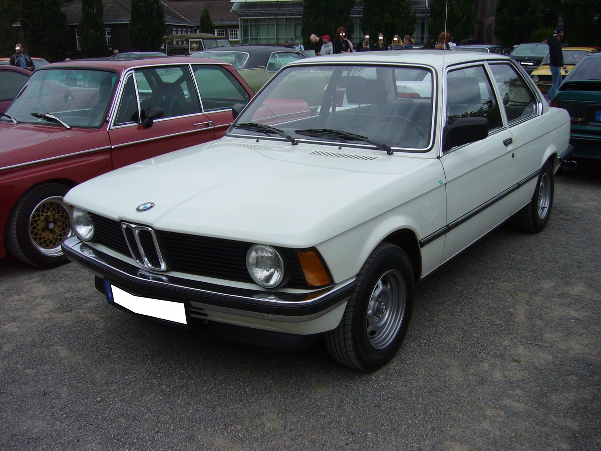 BMW E21 318i. 1980 - 1982. Die BMW Baureihe E21 stand ab Mai 1975 bei den Händlern. Mit dem Modelljahr 1980 stellten die Bayern die Kraftstoffzufuhr beim 318 von einem Solex Vergaser auf eine Bosch Saugrohr Benzineinspritzung um. Der Vierzylinderreihenmotor des abgelichteten, im Farbton alpinweiß lackierten Wagen, leistet nun 105 PS aus 1766 cm³ Hubraum. Die Höchstgeschwindigkeit liegt bei 175 km/h. Oldtimertreffen Nordsternpark Gelsenkirchen am 24.06.2018.