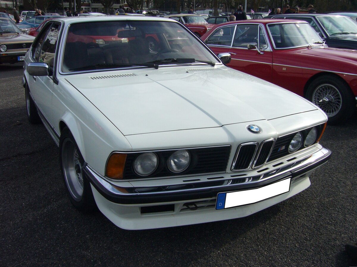 BMW E24 635 CSi, gebaut in den Jahren von 1978 bis 1987. Der abgelichtete E24 aus dem Jahr 1979 ist im Farbton alpinweiß lackiert. Der, mit einer rechtsseitigen Neigung von 30 Grad, verbaute Sechszylinderreihenmotor hat einen Hubraum von 3453 cm³ und leistet 218 PS. Die Höchstgeschwindigkeit wurde vom Werk mit 225 Km/h und der Verbrauch mit 15 Liter Superbenzin auf 100 Kilometer angegeben. Oldtimertreffen an Mo´s Bikertreff in Krefeld am 10.03.2024.