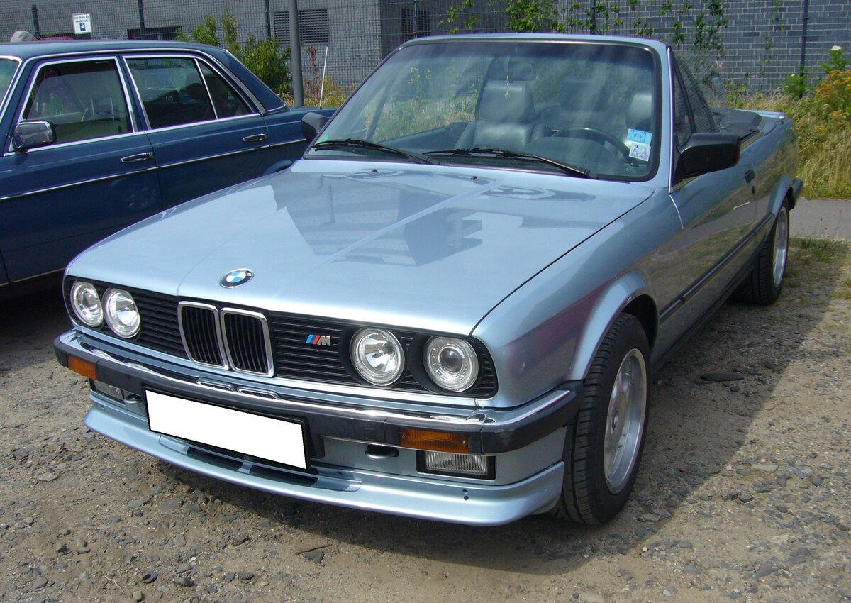 BMW E30 325i Cabriolet im Farbton gletscherblau. Das erste BMW-Vollcabriolet auf Basis der erfolgreichen E30-Baureihe feierte im September 1985 auf der Frankfurter IAA seine Premiere. Die ersten Fahrzeuge standen ab Mai 1986 bei den BMW-Händlern. Anfangs nur als 325i. Bereits 1987 wurde die Modellpalette mit dem 320i nach unten erweitert und 1990 folgte mit dem 318i die günstigste Version, einen offenen E30 zu fahren. Im Jahr 1993 wurde die Produktion des E30 Cabriolets eingestellt. Der Sechszylinderreihenmotor hat einen Hubraum von 2494 cm³ und leistet 170 PS. Oldtimertreffen an der  Alten Dreherei  in Mülheim an der Ruhr am 19.06.2022.