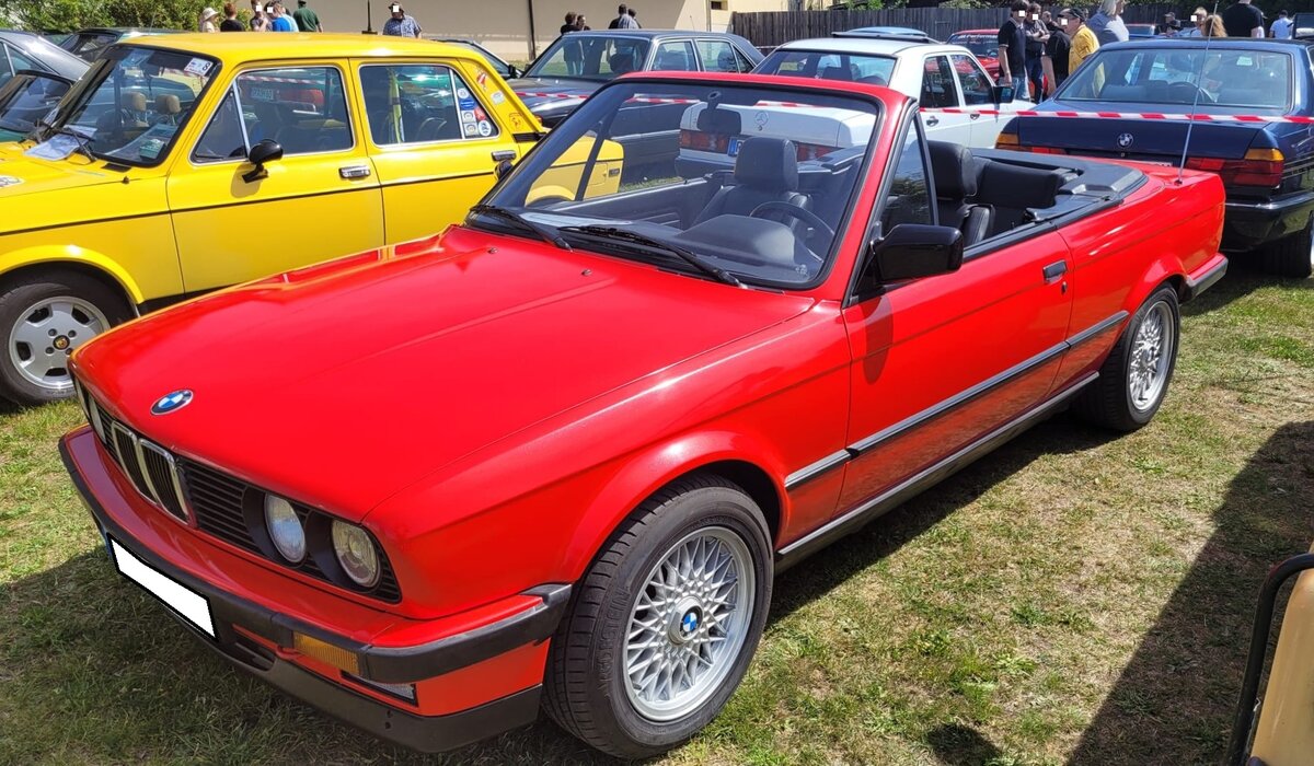 BMW E30 Cabriolet im Farbton brilliantrot. Das erste BMW-Vollcabriolet auf Basis der erfolgreichen E30-Baureihe feierte im September 1985 auf der Frankfurter IAA seine Premiere. Die ersten Fahrzeuge standen ab Mai 1986 bei den BMW-H�ndlern. Anfangs nur als 325i. Bereits 1987 wurde die Modellpalette mit dem 320i nach unten erweitert und 1990 folgte mit dem 318i die g�nstigste Version, einen offenen E30 zu fahren. Im Jahr 1993 wurde die Produktion des E30 Cabriolets eingestellt. Oldtimertreffen Altenthann/Oberpfalz am 03.05.2026.