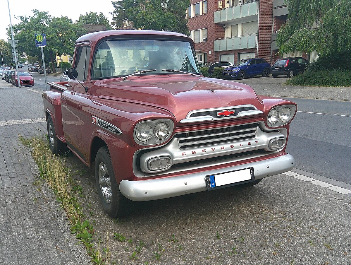 Chevrolet Apache 31 Stepside Truck aus dem Jahr 1958. Das Modelljahr 1958 war wegweisend, da Chevrolet in diesem Jahr das Design radikal modernisierte und den Trucks erstmals den Namen  Apache  gab. Die Zahl  31“ steht traditionell f�r die halbe Tonne Nutzlast mit kurzem Radstand. Im Jahr 1958 kamen erstmals Doppelscheinwerfer zum Einsatz. Ein solcher Truck war 1958 ab US$ 1884 zu bekommen. Bei der Motorisierung hatte der Kaufinteressent zwei Optionen: Den ber�hmten  Thriftmaster  Sechszylinderreihenmotor mit einem Hubraum von 235,5 cui (3859 cm�) und einer Leistung von 145 PS oder alternativ den  Trademaster  V8-Motor mit einem Hubraum von 283 cui (4638 cm�) und einer Leistung von 160 PS. Stra�enrandsichtung am 28.06.2026 in M�lheim an der Ruhr-Saarn.