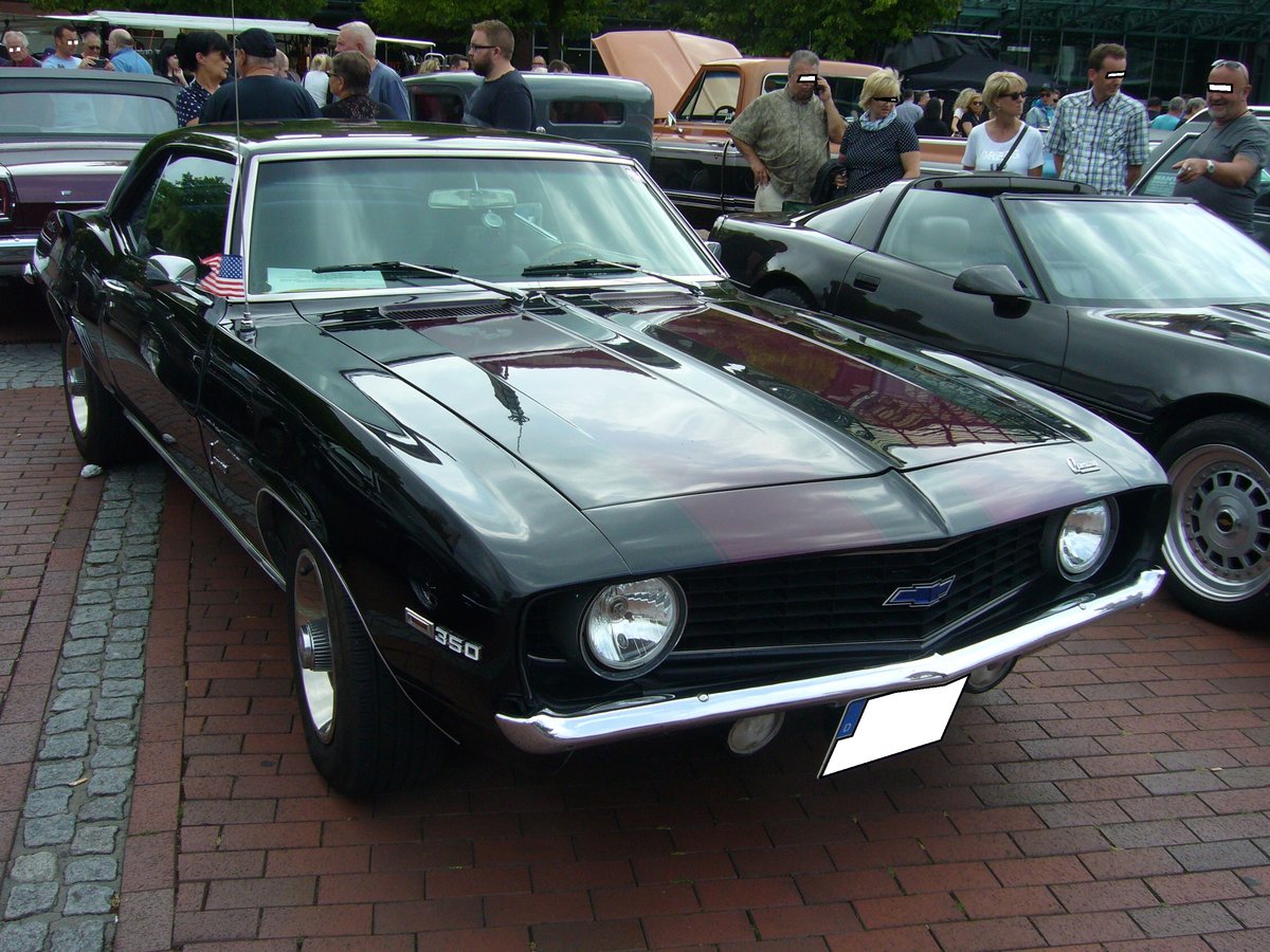 Chevrolet Camaro des Modelljahres 1969 im Farbton tuxedo black. Die Camaro´s bis zum Modelljahr 1969 werden der ersten Generation des 1966 vorgestellten Ford-Mustang-Konkurrenten Camaro zugerechnet. Der Camaro war mit etlichen Sechszylinderreihen- und V8-Motoren lieferbar. Der gezeigte Camaro ist mit einem V8-Motor ausgestattet der aus einem Hubraum von 350 cui (5735 cm³) eine Leistung von 250 PS an die Hinterachse wuchtet. US-Cartreffen am CentroO am 21.07.2019.