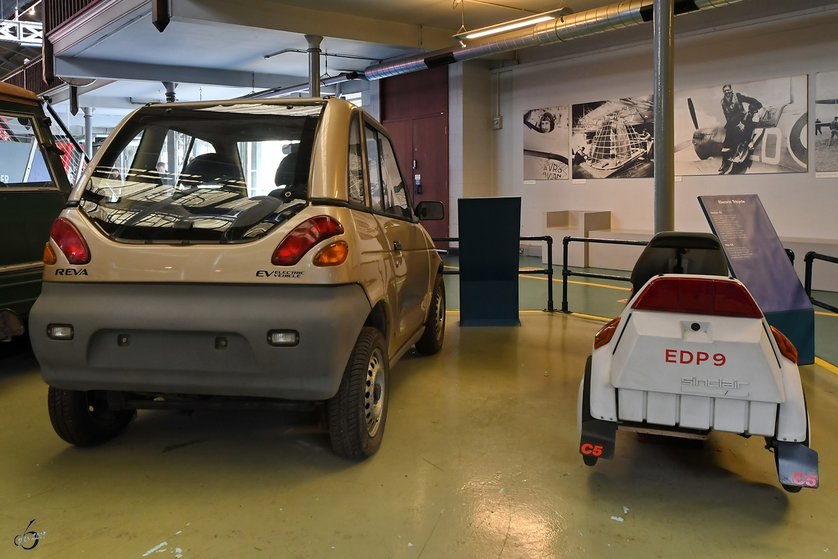 Das Elektro-Dreirad Sinclair C5 und das Elektro-Auto Reva G-Wiz im Museum of Science and Industry in Manchester. (Mai 2019) 