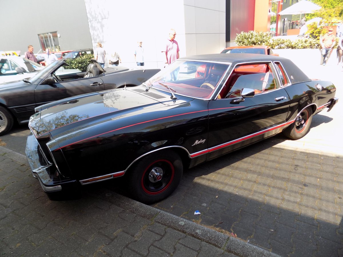 Das Ford Mustang II Stufenheckcoupe. Gebaut von 1973 bis 1978. Dieser Wagen stammt aus dem Jahr 1976 und ist im Farbton M1724 = black lackiert. In diesem Auto ist der 2799 cm³ große V6-Motor mit 97 PS verbaut. Oldtimertreffen Garage 10 in Gelsenkirchen am 21.04.2019.