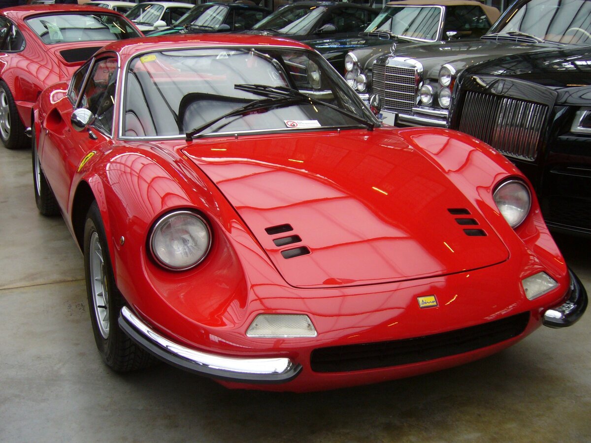 Dino 246GT, gebaut in den Jahren von 1969 bis 1973. Im Jahr 1966 gründete Enzo Ferrari die Marke Dino. Das unabhängige Unternehmen wurde, nach seinem im Alter von 24 Jahren verstorbenen Sohn Alfredino  Dino , benannt. 1969 erschien der harmonisch gezeichnete Dino 206 mit nur 2.0 Litern Hubraum. Nach nur ca. 100 verkauften Fahrzeugen wurde der V6-Motor auf einen Hubraum von 2418 cm³ aufgebohrt. Jetzt leistete der Wagen 195 PS und erreichte eine Höchstgeschwindigkeit von 230 km/h. Der gezeigte Dino verbrachte seine Autojugend im sonnigen Spanien. Classic Remise Düsseldorf am 26.02.2024.