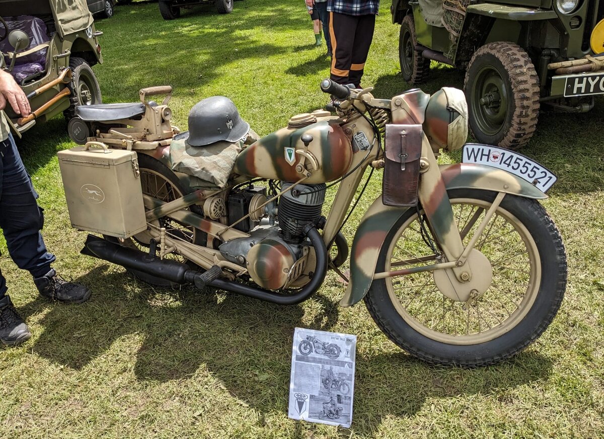 DKW NZ 350/1. Das zivile Krad DKW NZ 350 wurde seit 1938 produziert und im Jahre 1939 durch eine spezielle Version für staatliche Behörden ergänzt. Die NZ 350 hat einen Einzylinder-Zweitaktmotor mit einem Hubraum von 346 cm³ und einer Leistung von 11 PS. Das 171 Kilogramm wiegende Motorrad kann mit seinem Kraftstoffvorrat von 14 Litern etwa 320 km fahren und erreicht eine Höchstgeschwindigkeit von 90 km/h. Die DKW NZ 350-1 erschien 1943 und war den Anforderungen des WW2 besser angepasst. Hierbei wurde für den Motor hauptsächlich Grauguss anstelle von Aluminium verwendet. Weitere Unterscheidungsmerkmale der NZ 350-1 sind z.B. der kleinere Scheinwerfer und schmalere Kotflügel, um die Ansammlung von Dreck und Schlamm zu minimieren. Steam and vintage show am 27.05.2024 in Abergavenny/South Wales.