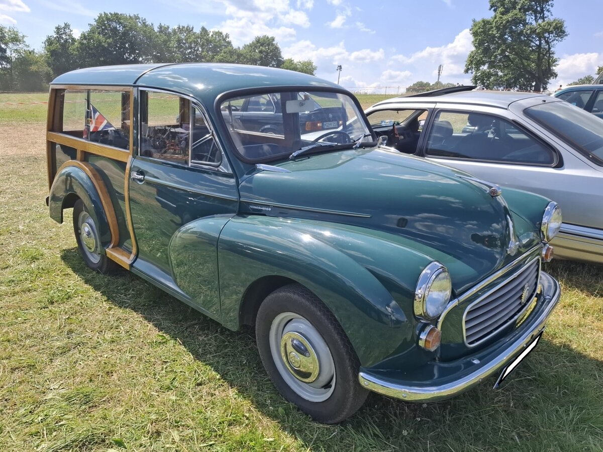 Ein links gelenkter Morris Minor 1000 Traveller, gebaut von 1953 bis 1971. Das Modell Minor wurde bereits 1948 als Morris MM vorgestellt. Erst im Jahr 1953, da lief schon der Morris Minor Series II, wurde der Traveller mit Holzaufbau im so genannten  Woody-Look  vorgestellt. Der abgelichtete Morris d�rfte Farbton almond green lackiert sein. Angetrieben wird der Kombi von einem Vierzylinderreihenmotor, der aus einem Hubraum von 1098 cm� genau 50 PS leistet. Dittmers Hoffest am 12.07.2026 in Sprockh�vel.