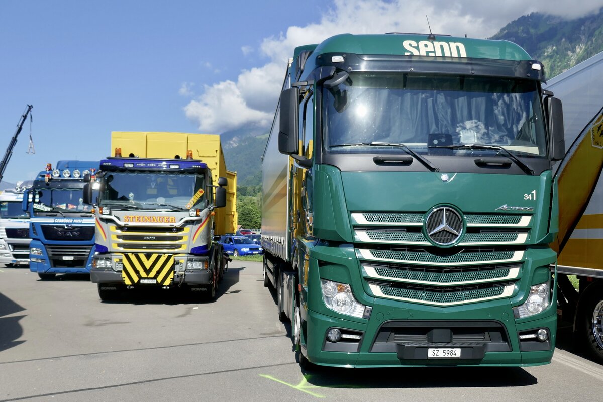 Ein MB Actros Sattelzug von Senn, ein Scania mit Absetzkipper von Steinauer und ein MAN von Gebrüder Husi am 26.6.22 beim Trucker Festival Interlaken.