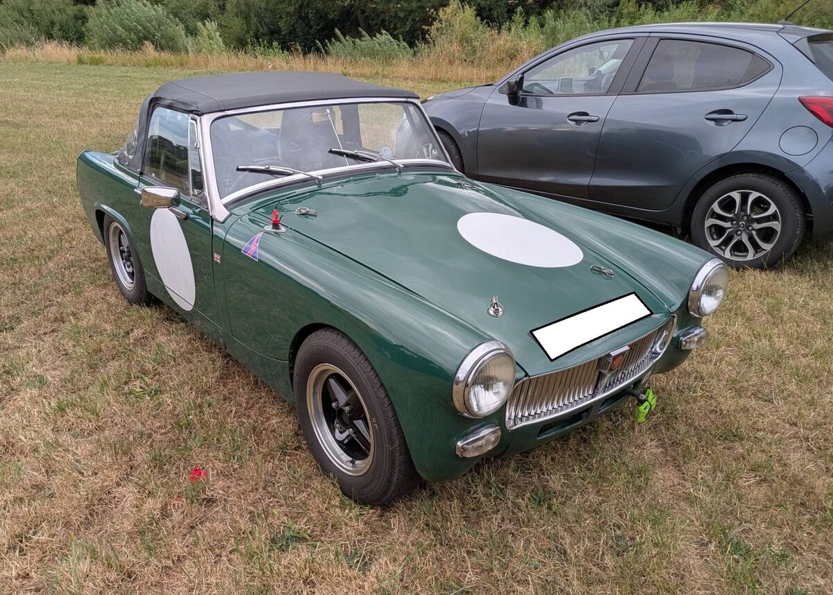 Ein sportlich aufgemachter MG Midget MK3 im Farbton brooklands green, gebaut von 1966 bis 1974. Der Midget, zu deutsch  Zwerg , wurde bereits 1961 vorgestellt und permanent optisch und technisch leicht ver�ndert. Im MK3 war der Motor des Mini-Cooper S verbaut. Der Vierzylinderreihenmotor hat einen Hubraum von 1275 cm�, sp�ter 1297 cm� und leistet serienm��ig 65 PS. Treffen des Chainbridge classic car club auf der Wiese vor einem Pub in Chainbridge/Wales im Juli 2025.