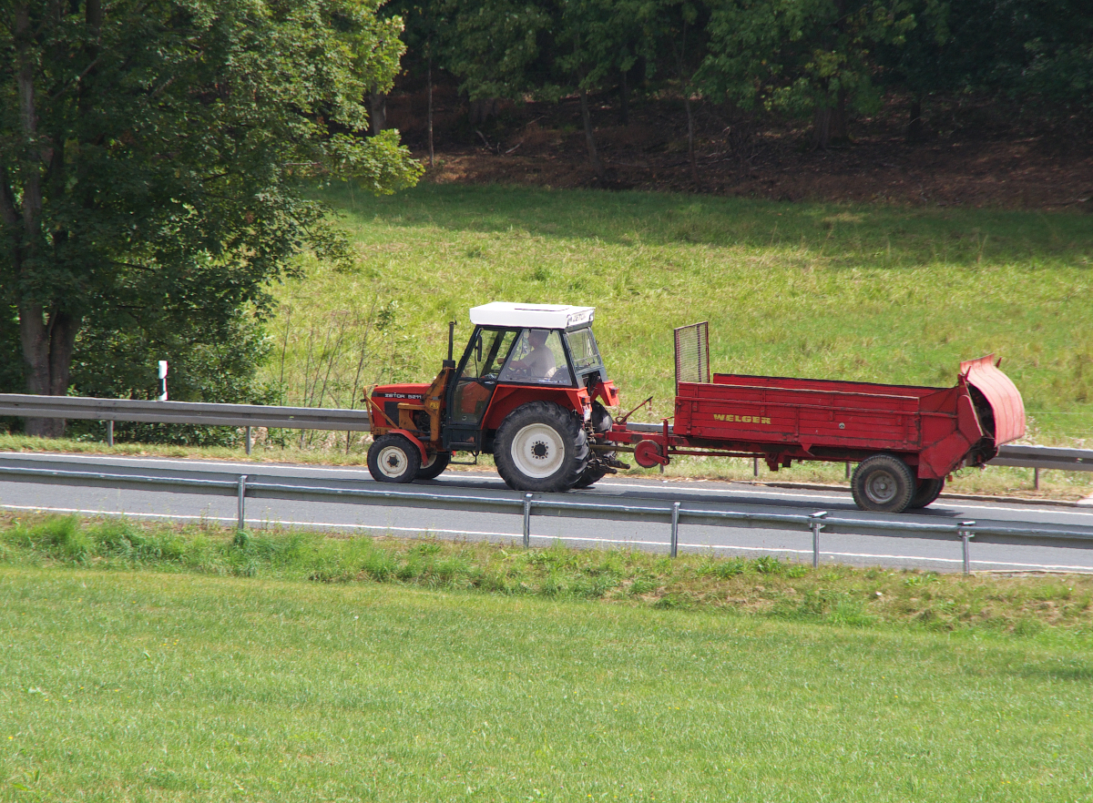 Ein Zetor 5211 brummt mit seinem Anhang über die B2 zwischen Dobareuth und Gefell.
Zetor ist ein Traktorenhersteller mit Sitz in Brünn. Das Unternehmen wurde 1946 gegründet. Der 5211 hat 45 PS und stammt aus den 1980er Jahren. 15.08,2015