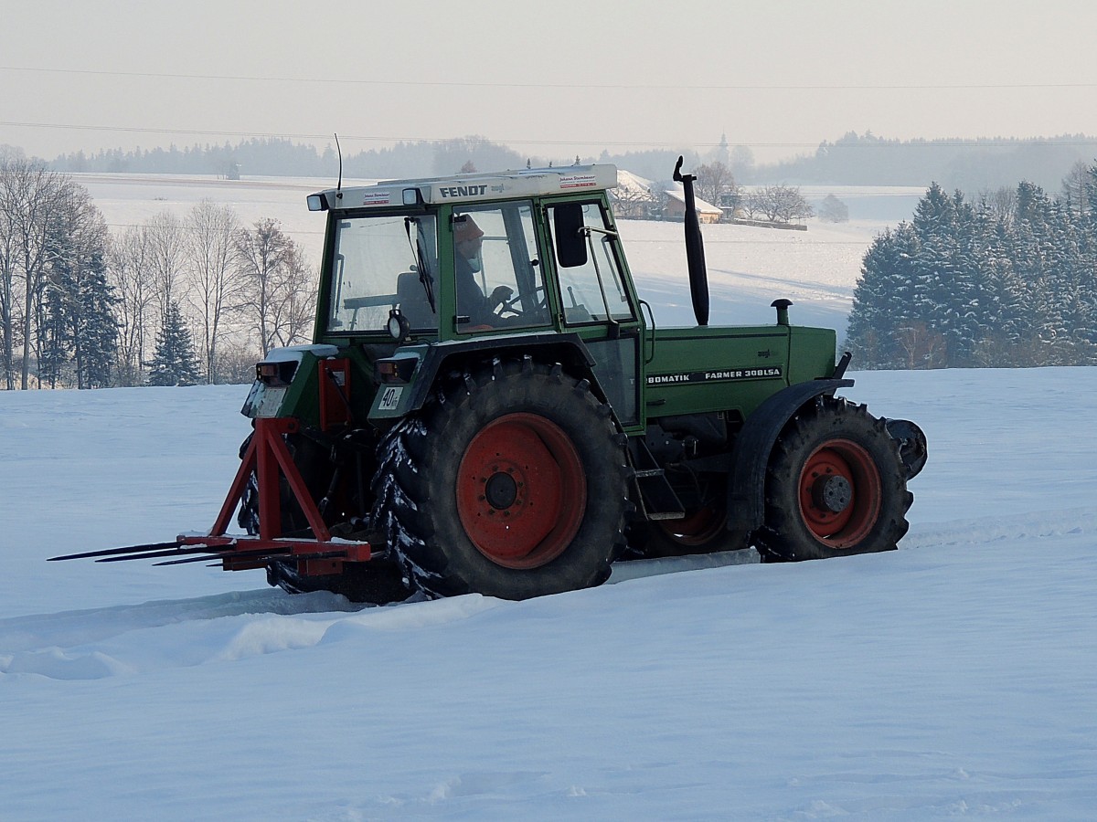 FENDT Farmer308LSA Turbomatic, ist in winterlicher Landschaft am Weg um Siloballen zu holen; 130119