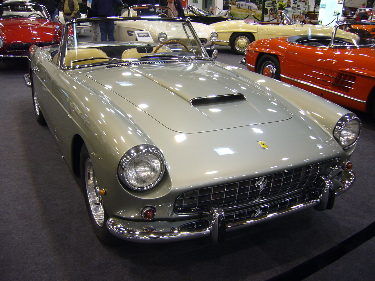 Ferrari 250 GT Cabriolet der Seria 2, gebaut von 1960 bis 1962. Das 250 GT Cabriolet wurde bereits im Jahr 1957 vorgestellt. Ab 1960 konnten die Modelle der Seria 2 bestellt werden. Insgesamt verließen ca. 200 Autos dieses Typs die Werkshallen in Maranello. Der V12-Motor hat einen Hubraum von 2953 cm³ und eine Leistung von 280 PS. Die Höchstgeschwindigkeit betrug gemäß Werksangaben 252 km/h. Der gezeigte Wagen wurde im Jahr 1962 erstamlig in Italien zugelassen. Techno Classica Essen am 13.04.2023.