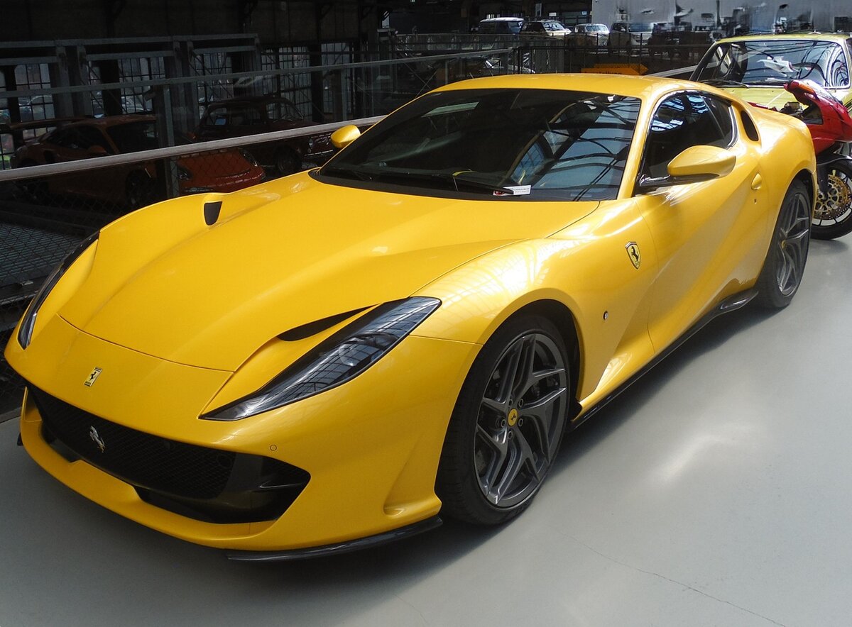 Ferrari 812 Superfast im Farbton giallo triple strato aus dem Jahr 2019. Der 2017 vorgestellte 812 Superfast ist bis dato das stärkste Serienmodell der Marke mit dem  Cavallo Rampante  im Markenlogo. Er ist als Coupe (Foto) oder Cabrioletmodell GTS lieferbar. Der V12-Motor hat einen Hubraum von 6496 cm³ mit einer Leistung von genau 800 PS. Die Beschleunigung von 0 auf 200 km/h schafft diese  Flunder  in 8,5 Sekunden. Die Höchstgeschwindigkeit wurde mit 340 km/h gemessen. Classic Remise Düsseldorf im September 2024.