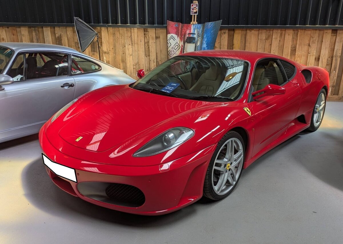 Ferrari F430 Berlinetta im klassischen Ferrari-Farbton rosso corsa. Im M�rz 2005 l�ste die Baureihe F430 die Baureihe 360 ab. Das Modell war als klassisches Coupe (Foto) oder als Cabriolet-Modell Spider lieferbar. Optisches Highlight bei diesem Modell ist die verglaste Motorhaube, die den Blick auf den V8-Motor frei gibt. Dieser hat einen Hubraum von 4308 cm� und leistet rund 490 PS. Der gezeigte, rechts gelenkte F430, wurde erstmalig im Juni 2007 zum britischen Stra�enverkehr zugelassen. Ausstellungsraum des Oldtimer-H�ndlers  Ignition Sheed  in Abergavenny/S�d Wales am 17.05.2025.
