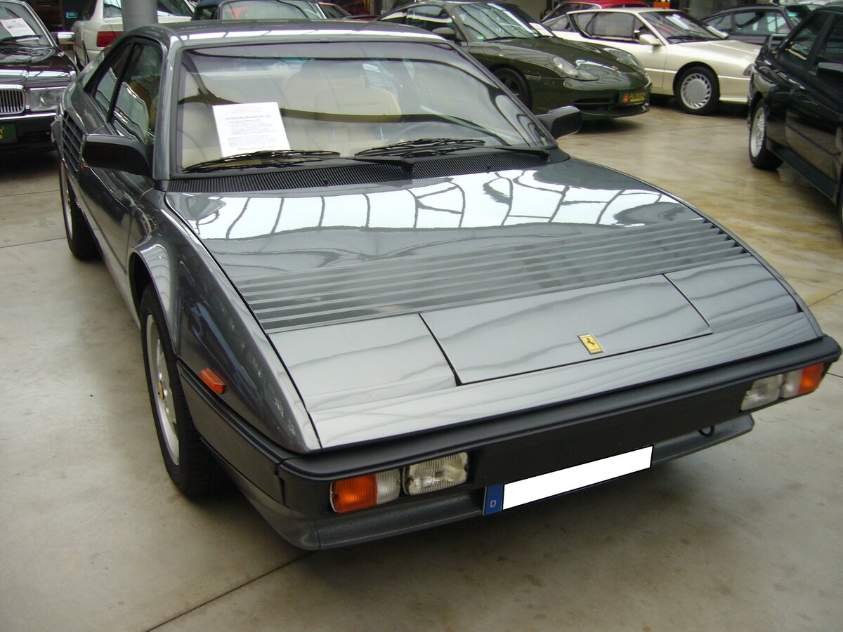 Ferrari Mondial Quattrovalvole 3.0 Coupe, gebaut von 1982 bis 1985 in 1144 Einheiten. Angetrieben wird der Wagen von einem V8-Motor, der aus einem Hubraum von 2926 cm³ 240 PS leistet. Die Höchstgeschwindigkeit gab man in Maranello mit 242 km/h an. Classic Remise Düsseldorf am 13.07.2021.