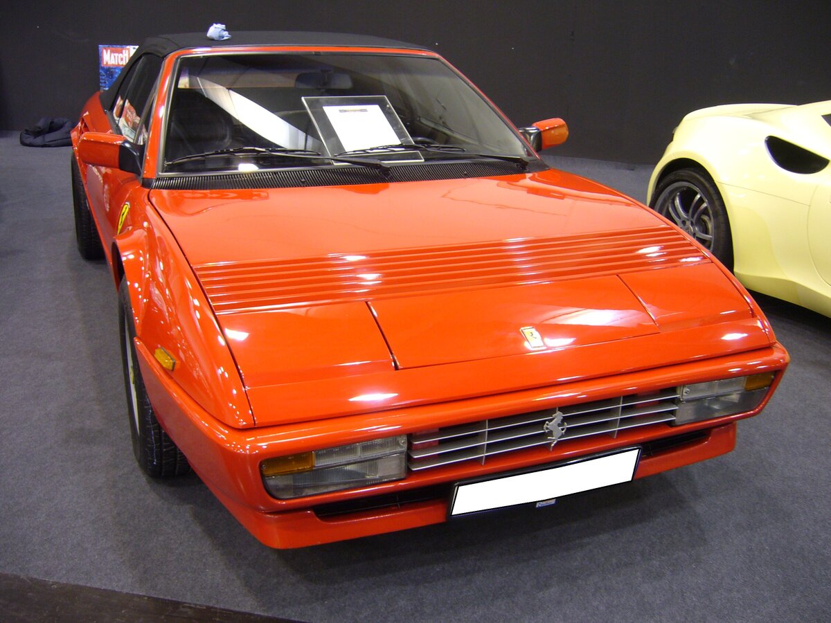 Ferrari Mondial QV Cabriolet, gebaut von 1982 bis 1985. Das Modell wurde bereits im Jahr 1980 als Mondial 8 vorgestellt. Das Modell, dessen Karosserie von Pininfarina gezeichnet wurde, konnte als Coupe und Cabriolet bestellt werden. Der als Mittelmotor verbaute V8-Motor hat einen Hubraum von 2926 cm³ und leistet 239 PS. Die Höchstgeschwindigkeit gab man in Maranello mit 242 km/h an. Essen Motor Show am 06.12.2022.