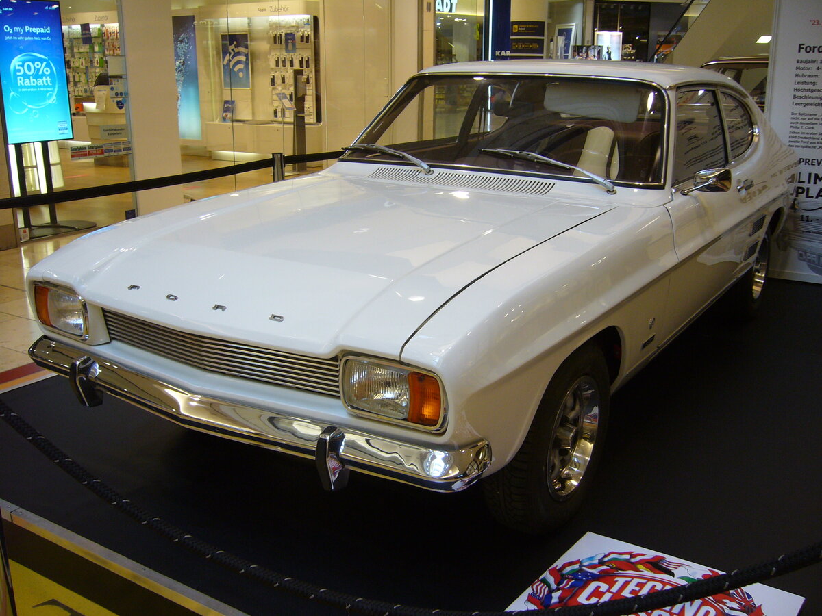 Ford Capri 1, gebaut von 1969 bis 1973. Der Capri 1 wurde von den deutschen und englischen Ford-Werken gemeinsam entwickelt und im Januar 1969 vorgestellt. Das Modell beeinflusste die Verkaufszahlen von Ford äußerst positiv. Der Capri war mit einer breit gefächerten Motorenauswahl bestellbar. Der abgelichtete Capri ist ein 1500´er im Farbton diamantweiß in der Ausstattungsvariante XL aus dem ersten Modelljahr. Der 1500´er war die zweit kleinste Motorisierungsversion. Der V4-Motor hat einen Hubraum von 1498 cm³ und leistet 60 PS. Das verhilft dem Wagen zu einer Höchstgeschwindigkeit von 142 km/h. Ein solcher Capri stand bei seiner Markteinführung mit einem Basispreis von DM 7300,00 in der Preisliste. Schon in seinem ersten Verkaufsjahr steigerte der Capri den Marktanteil von Ford/Deutschland auf ca. 16%. Bereits im Jahr 1970 war fast jeder zweite in Deutschland gebaute Ford ein Capri. Sogar in die USA wurde der Capri exportiert und unter dem Label der Ford-Division Mercury vertrieben. EKZ Limbecker Platz in Essen am 12.03.2022.